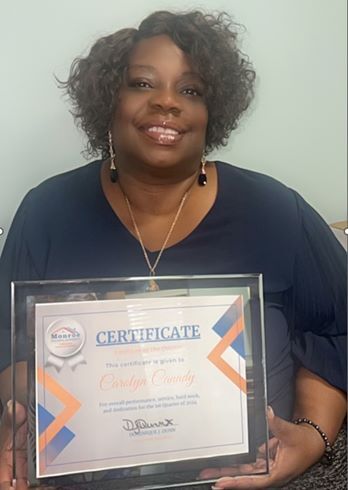 Carolyn Canady smiling and holding a certificate. 
